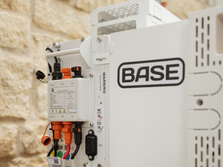A Base Power battery sits next to a home.