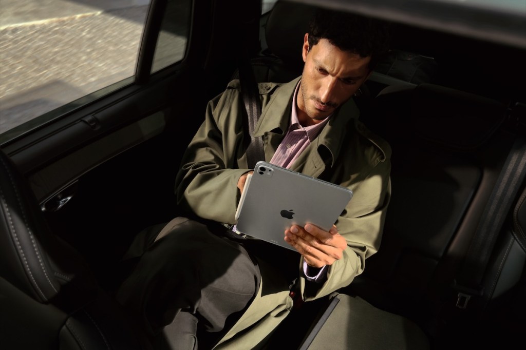 man looking at Apple tablet