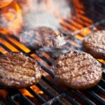 Cooking Burgers On Hot Grill With Flames
