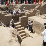 Archaeologists stand at the entrance to a Chimú-era mausoleum discovered at the Utzh An complex in Chan Chan.