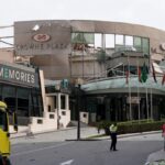 Security and civil defense workers stand outside the damaged Crown Plaza hotel, following an Iranian military strike, in Manama on March 1, 2026.