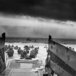 A landing craft from the USS Samuel Chase unloads Allied troops onto the Fox Green section of Omaha Beach in northern France under moody skies on the morning of D-Day, June 6, 1944.