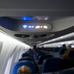 A Wi-Fi and fasten seat belts sign illuminated on a Delta Air Lines plane.