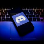 Discord logo displayed on a phone screen and a keyboard.