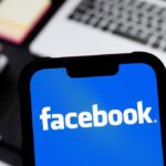 photo illustration of Facebook logo is seen displayed on a smartphone.