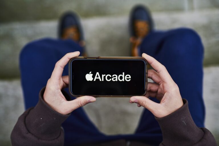 Apple Arcade video game subscription service signage is displayed on an iPhone
