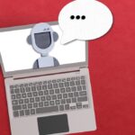 AI agent concept with robot inside a laptop with a voice bubble on red background.