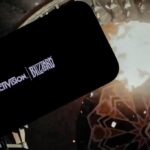 logo of ''Activision Blizzard'' is displayed on a mobile phone screen in front of a computer