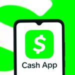 In this photo illustration, the Cash App logo is seen displayed on a smartphone screen.
