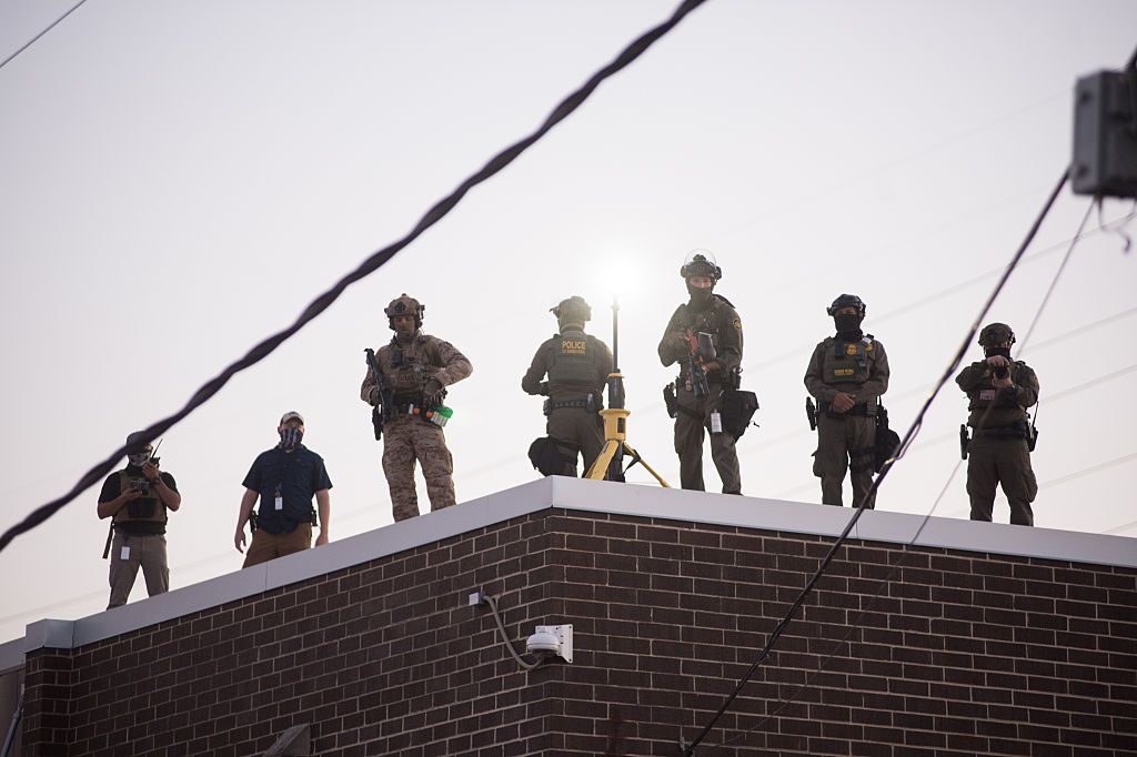 U.S. Immigration and Customs Enforcement (ICE) agents, Department of Homeland Security (DHS) personnel, and Border Patrol Commander Gregory Bovino stand together amidst a tense protest outside the ICE processing facility in Broadview, Illinois, on September 27, 2025.