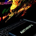 In this photo illustration, the Anthropic logo is displayed on a mobile phone screen against a world map.