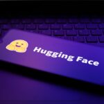 The Hugging Face logo appears on the screen of a smartphone.