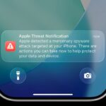 an Apple threat notification on an iPhone lock screen.