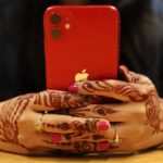 red iPhone held in two hands