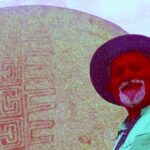 Harman poses in front of an example of the Rancho Bernardo style of Native American artwork.