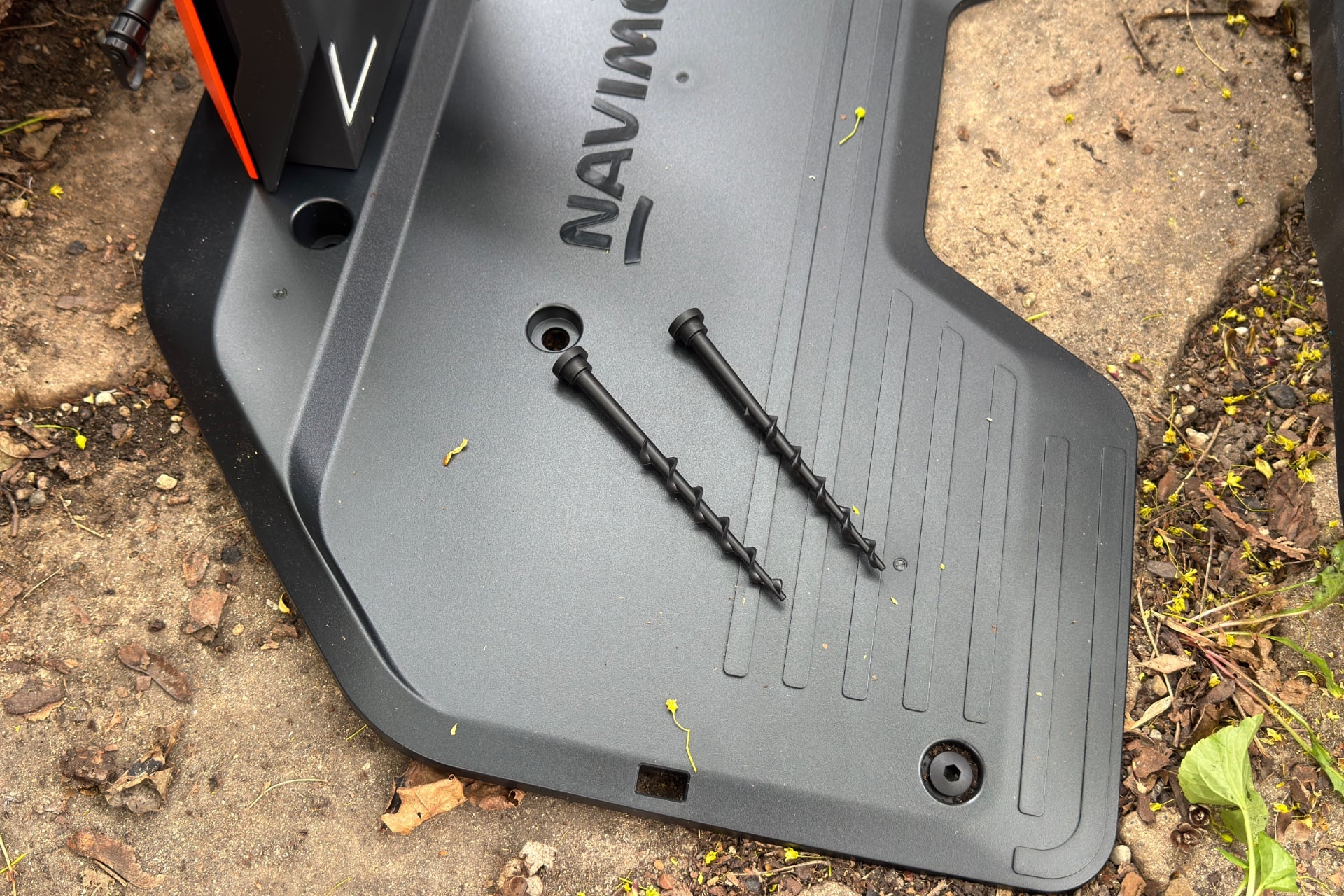 navimow-x430-dock-anchor-screws-1 The Navimow dock's ground plate with two anchor screws resting on it.
