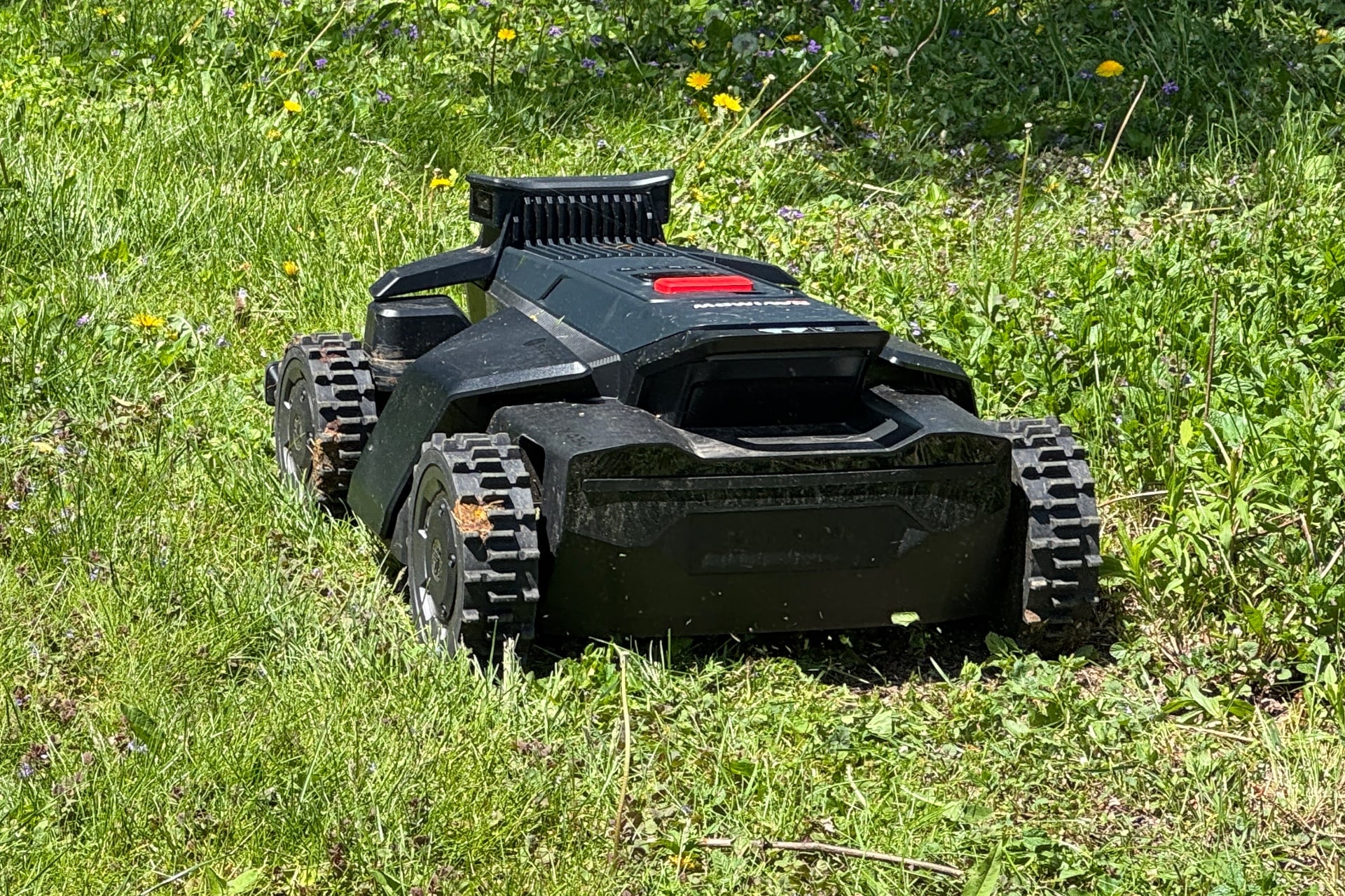 navimow-x430-mowing-1 Navimow X430 pictured from behind, mowing through grass.