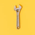 Adjustable wrench on yellow background