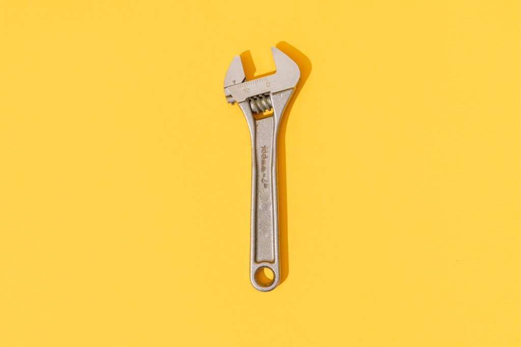 Adjustable wrench on yellow background