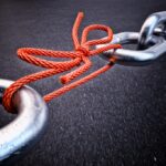 Metallic chain connected by a red knotted rope, representing third party cybersecurity risk