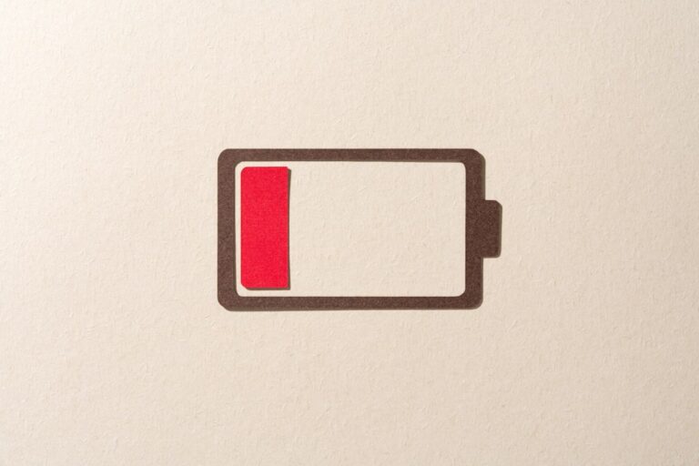 Paper Cut Craft Battery Only Has One Red Cell Left on Beige Background Directly Above View.