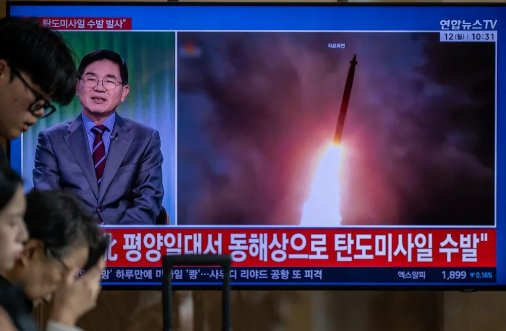 TOPSHOT - News coverage showing file footage of a North Korean missile launch is seen on a screen at Seoul Station in Seoul on October 12, 2026. North Korea on October 12 fired multiple ballistic missiles off its east coast, Seoul's military said, after weeks of mounting friction over a landmine explosion along the countries' heavily fortified border. (Photo by Philip FONG / AFP via Getty Images)