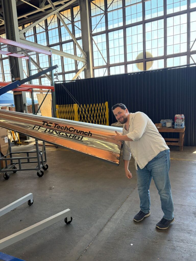 Longshot CEO and cofounder Mike Grace with a projectile designed to be fired from his company's enormous gun.